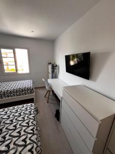 a bedroom with a bed and a desk and a tv at Residence Balcòn del Atlàntico Costa Adeje in Adeje +23 photos