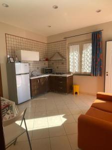a kitchen with a white refrigerator and a couch at Villa Aura in Torre del Greco