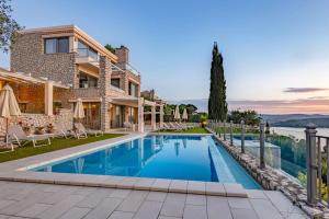 a villa with a swimming pool in front of a house at Villa Isabelle with superb views in Lygia