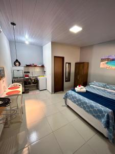 Großes Zimmer mit einem Bett und einer Küche. in der Unterkunft Paraíso do Boldró Flat in Fernando de Noronha