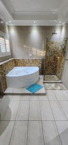 a large bathroom with a tub and a shower at The grand palm in Pretoria