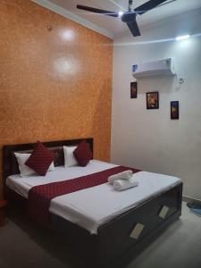 a bedroom with a bed with red and white pillows at Ramam hotel by Naavagat Ayodhya in Ayodhya