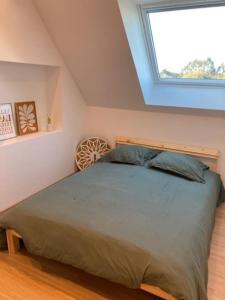 um quarto com uma cama grande e uma janela em Jolie maison binicaise em Gicquel