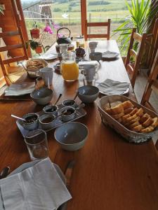 uma mesa de madeira com comida e pão em La Rose des Vents em Les Vastres