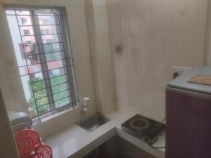 a small bathroom with a sink and a window at Secured Family Studio Apartment-near Airport,AC,Fridge,WiFi,Stove in Dhaka