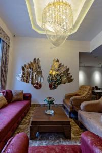 ein Wohnzimmer mit Sofas und einem Kronleuchter in der Unterkunft Aqua Hotel in Tbilisi City
