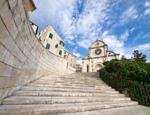 a stairway leading up to a building with a church at Cozy country home with heated outdoor pool in Šibenik