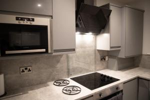 a kitchen with a stove and a microwave at 2 Bedroom Property with Free Parking close to Leeds City Centre in Leeds