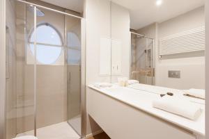 a white bathroom with a sink and a shower at Brera Apartments in Garibaldi in Milan