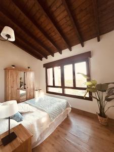a bedroom with a bed and a large window at Los Castros Apartamentos Rurales A in Llames de Pría