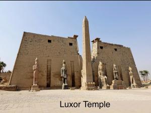 un edificio con estatuas frente a un monumento en Full Moon House, en Luxor