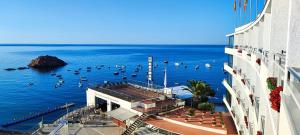 un grupo de barcos en el agua al lado de un edificio en Gran Hotel Reymar, en Tossa de Mar