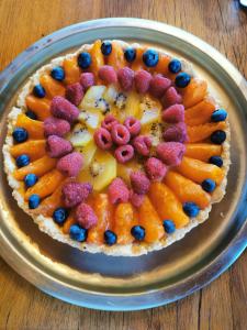 a fruit tart on a plate on a table at La Rose des Vents in Les Vastres