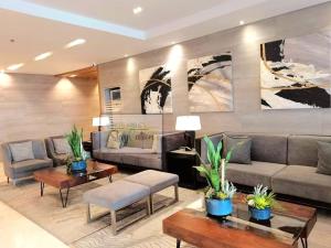 a living room with couches and tables and plants at Condo in Pasay S Residences in Manila