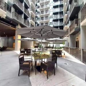 a patio with a table and chairs with an umbrella at Condo in Pasay S Residences in Manila