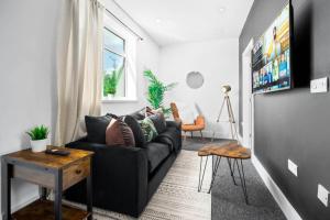 un soggiorno con divano nero e finestra di New Luxe Apartment - Parking - Smart TV - WIFI - Rated Exceptional - 49BG a Sleightholme