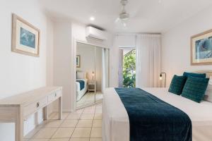 棕榈湾Ivy at Coral Horizons: A Retro Beachfront Locale的白色卧室设有一张大床和镜子 更多17张照片