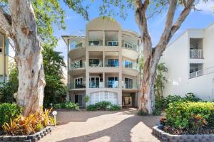棕榈湾Ivy at Coral Horizons: A Retro Beachfront Locale的一栋前面有树的公寓楼