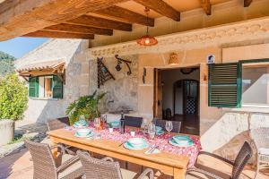 einen Holztisch und Stühle auf einer Terrasse in der Unterkunft Finca Los Valles in Campanet