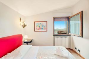 a bedroom with a red bed and a window at Quadro d'Autore, Terre Marine in Campiglia