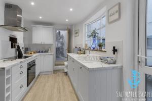 a kitchen with white cabinets and a sink at Little Fish in Brixham