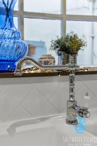 a bathroom sink with a chrome water faucet at Little Fish in Brixham