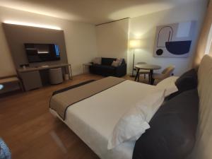a hotel room with a bed and a living room at Vittoria Parc Hotel in Bari