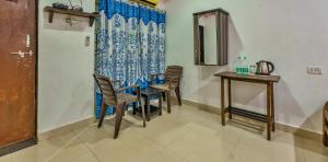 a dining room with chairs and a table and a mirror at QnQ Beach Walk in Calangute