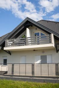 a white house with a balcony on top of it at Love House Balatonboglár Apartman in Balatonboglár +8 photos