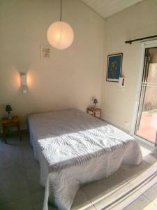 a bedroom with a bed and a large window at Villa Occhiatana, Santa Giulia in Porto-Vecchio