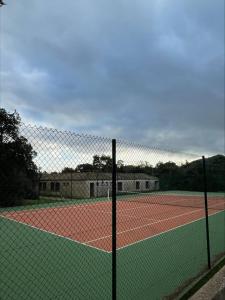 a tennis court with a net on a tennis court at Villa Occhiatana, Santa Giulia in Porto-Vecchio