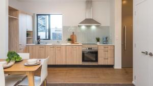 a kitchen with wooden cabinets and a wooden table at Hagley park Hidden Gem in Christchurch
