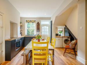a kitchen with a dining table and yellow chairs at 4 Bed in Harrogate 73424 in Harrogate
