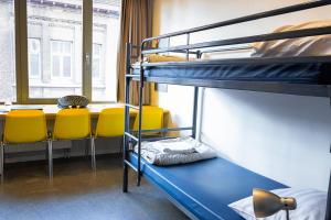 Hostel Van Gogh في بروكسل: غرفة بسريرين بطابقين وطاولة وكراسي