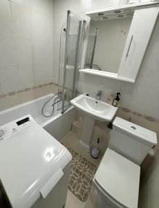 a bathroom with a sink and a toilet and a mirror at Apartment Amber Liepaja in Liepāja