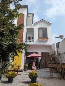 朔莊的住宿－Mai Anh Garden，白色的房子,配有桌子和雨伞