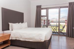 a bedroom with a large bed and a large window at Cherrywood Estate Apartment in Blantyre