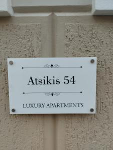un panneau sur un mur indiquant les appartements de luxe dans l'établissement Atsiki's 54 apartments, à Chios