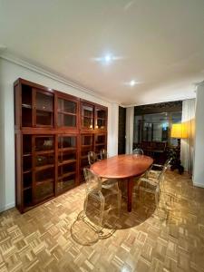 uma sala de jantar com uma mesa de madeira e cadeiras em Sor Angela Apartment em Madri