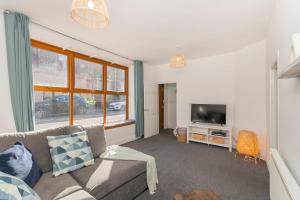 a living room with a couch and a television at The Space by Afan Valley Escapes in Port Talbot