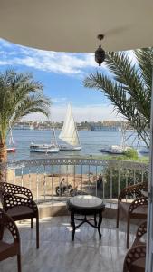 a balcony with a view of a sailboat on the water at Full Moon House in Luxor