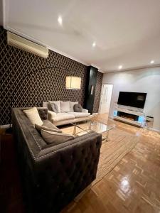 uma sala de estar com um sofá e uma televisão em Sor Angela Apartment em Madri