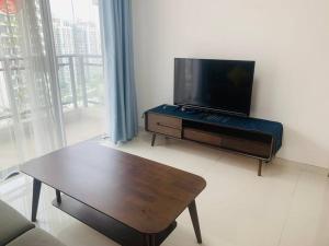 温馨别致1+2房 في Kampong Pok Kechil: غرفة معيشة مع تلفزيون وطاولة قهوة