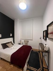 um quarto com uma cama grande e uma parede branca em Sor Angela Apartment em Madri