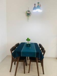 温馨别致1+2房 في Kampong Pok Kechil: طاولة مع قماش الطاولة الزرقاء وكرسيين