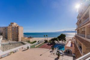 Blick auf den Strand, ein Gebäude und das Meer in der Unterkunft Seaview Getaway: Beach Access, Pool & Tennis Court in Faro de Cullera