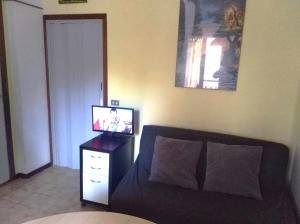 - un salon avec un canapé et une télévision sur une commode dans l'établissement Conero 33Casa Vacanze, à Marcelli