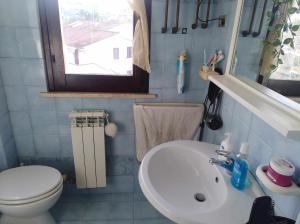 La petite salle de bains est pourvue d'un lavabo et de toilettes. dans l'établissement Conero 33Casa Vacanze, à Marcelli