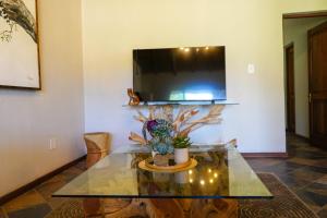 a living room with a glass table and a tv at Lucca House in Musina