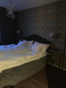 un letto con lenzuola e cuscini bianchi in una camera da letto di Riverside Apartments ad Ängelholm